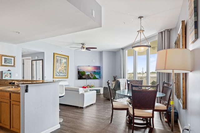 dining space with dark wood-type flooring, sink, and ceiling fan