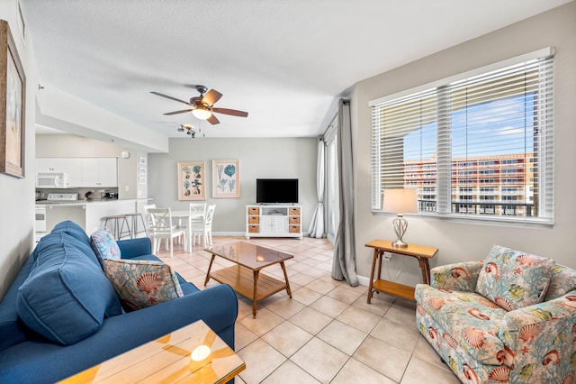 tiled living room with a textured ceiling and ceiling fan