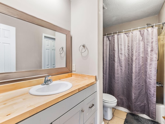 bathroom featuring vanity, tile patterned flooring, toilet, and a textured ceiling