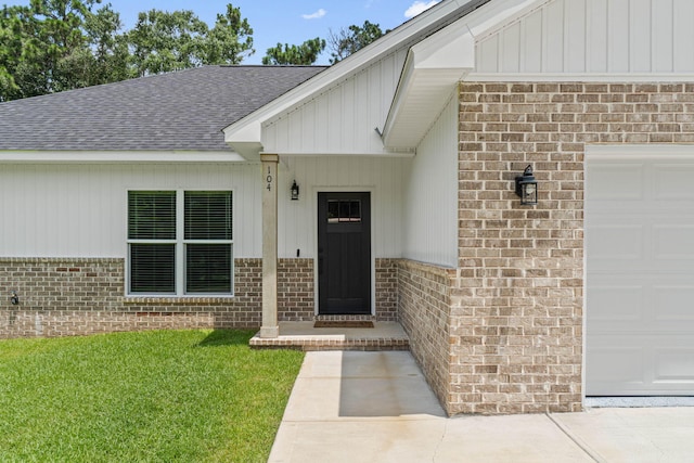 doorway to property featuring a garage and a yard