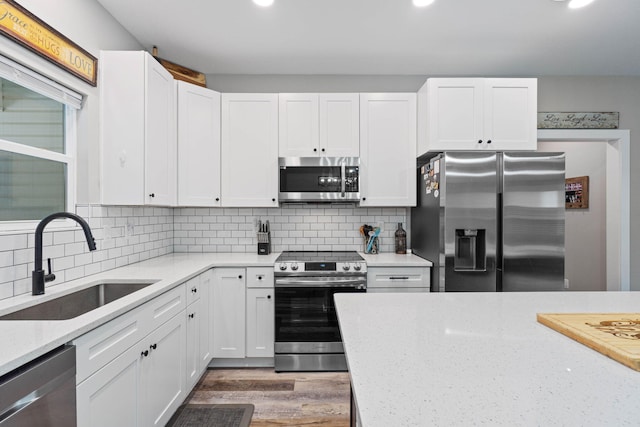 kitchen featuring stainless steel appliances, white cabinetry, and sink