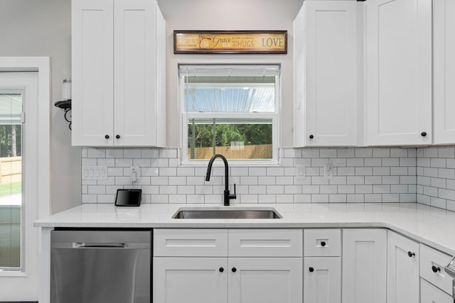 kitchen featuring sink, backsplash, light stone countertops, white cabinets, and stainless steel dishwasher