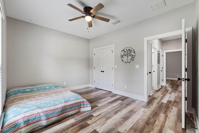 bedroom with hardwood / wood-style floors, a closet, and ceiling fan