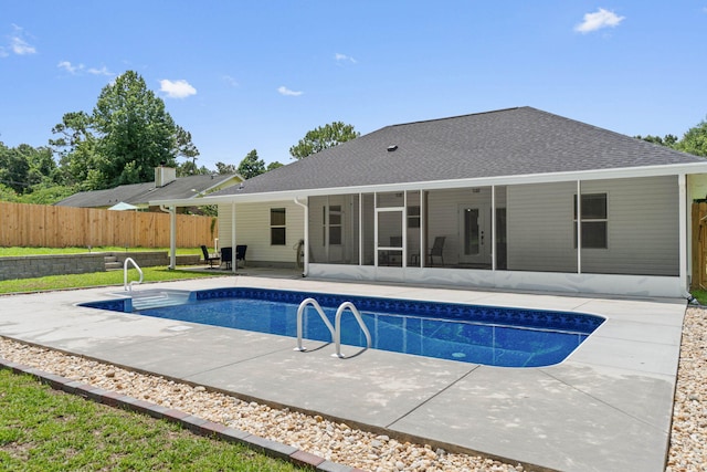 view of swimming pool with a sunroom and a patio