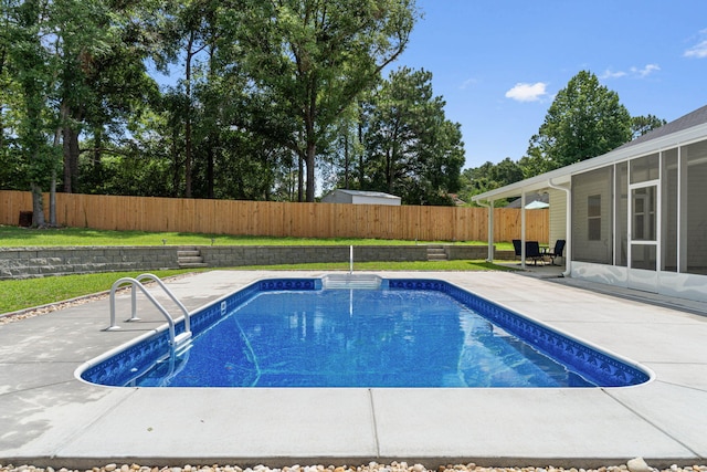 view of swimming pool with a sunroom and a patio area