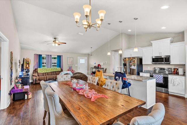 dining space with sink, ceiling fan with notable chandelier, high vaulted ceiling, and dark wood-type flooring