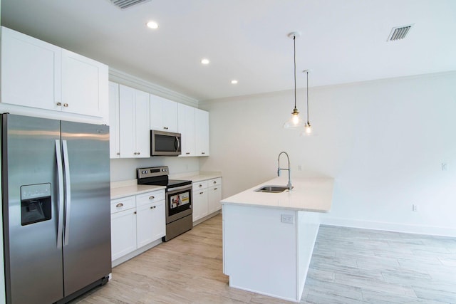 kitchen featuring sink, white cabinetry, decorative light fixtures, a center island with sink, and stainless steel appliances