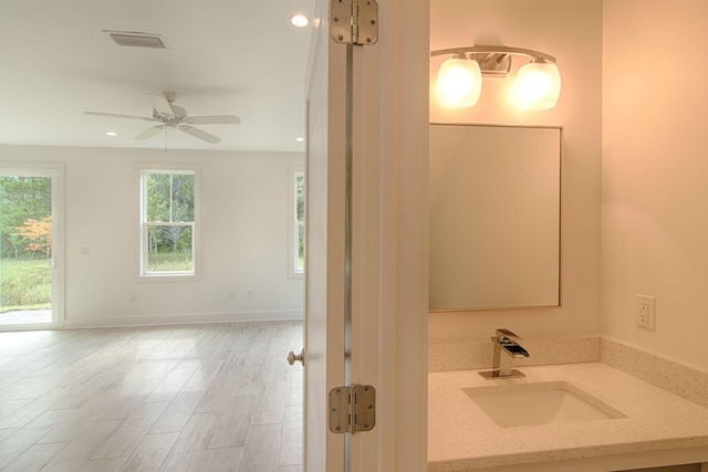 bathroom with vanity, ornamental molding, hardwood / wood-style floors, and ceiling fan