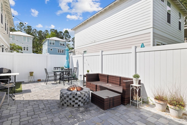 view of patio with an outdoor living space with a fire pit