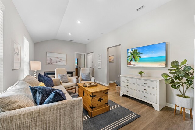 living room featuring light hardwood / wood-style flooring and lofted ceiling