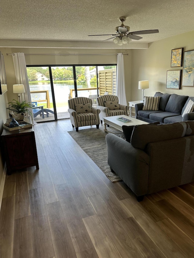 living room with hardwood / wood-style flooring, ceiling fan, and a textured ceiling