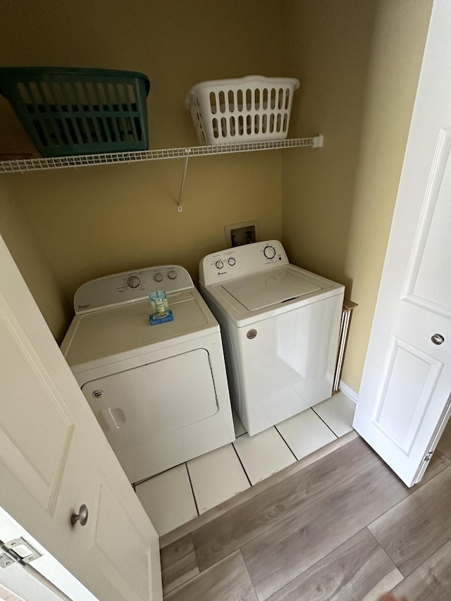 laundry room with separate washer and dryer and light wood-type flooring