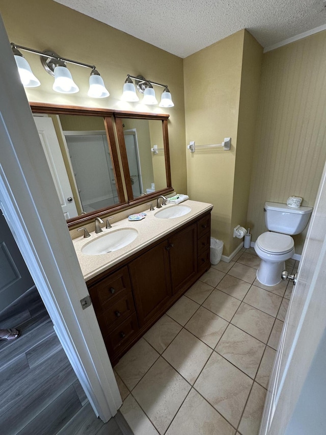 bathroom featuring tile patterned floors, vanity, toilet, and a textured ceiling