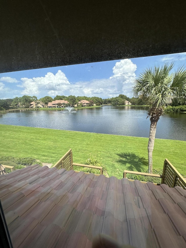 wooden deck with a yard and a water view