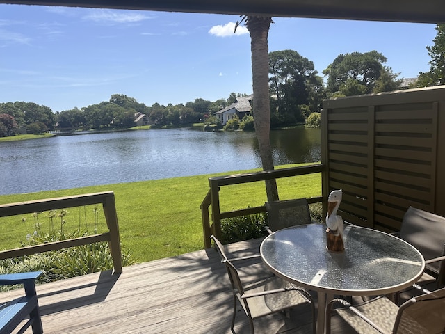 wooden terrace featuring a water view and a yard