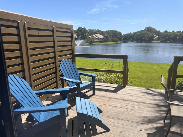 deck with a water view and a lawn