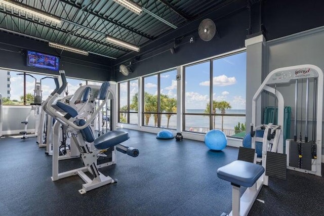 exercise room with a wealth of natural light and a water view