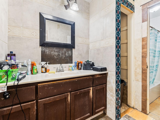 bathroom with tile patterned flooring, tile walls, and vanity