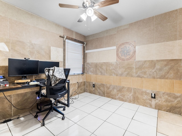 office space featuring tile walls, ceiling fan, and light tile patterned floors