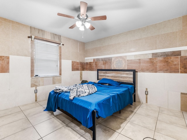 tiled bedroom featuring tile walls and ceiling fan