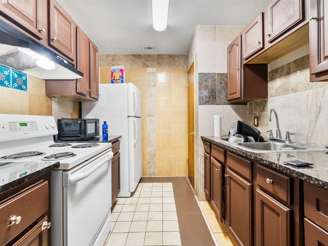 kitchen featuring light tile patterned floors, sink, white electric range oven, and tile walls