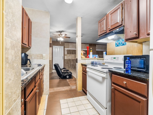 kitchen featuring ceiling fan, tile walls, electric range, sink, and light tile patterned floors