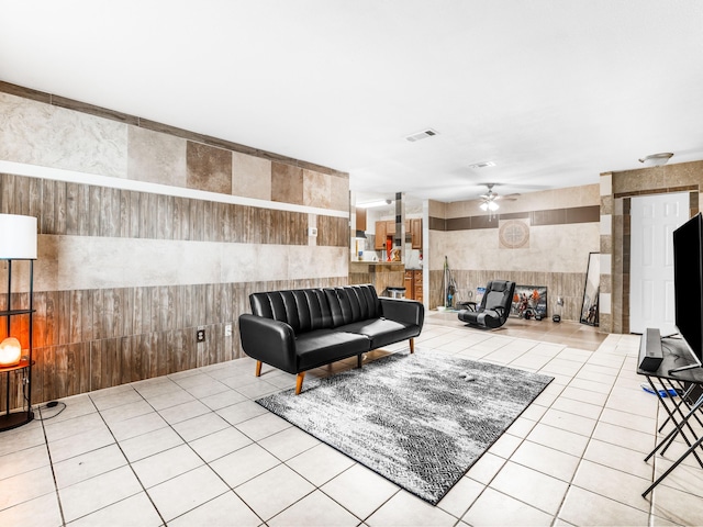 tiled living room featuring tile walls and ceiling fan