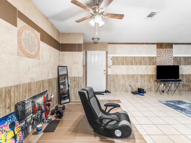 office space featuring tile walls, ceiling fan, and light tile patterned floors