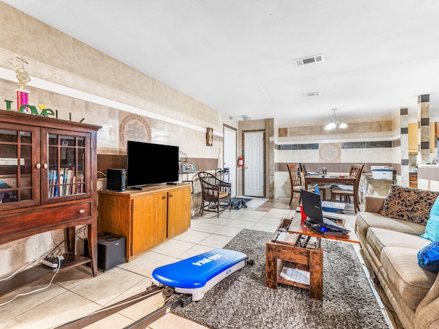 tiled living room featuring tile walls and a notable chandelier