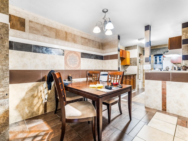 tiled dining space with a notable chandelier and tile walls