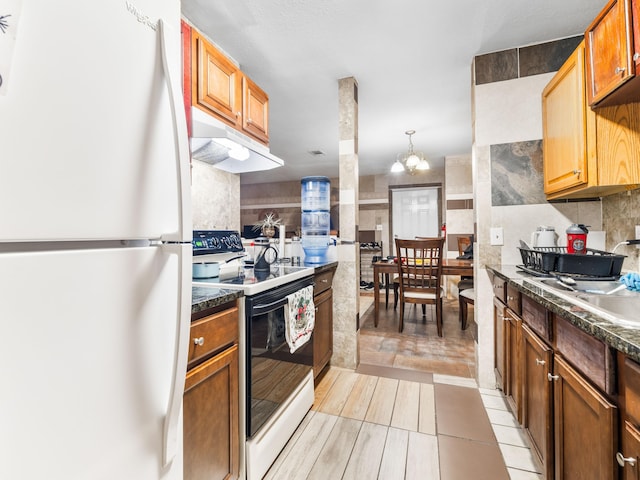 kitchen with white appliances, sink, decorative light fixtures, light tile patterned flooring, and a chandelier