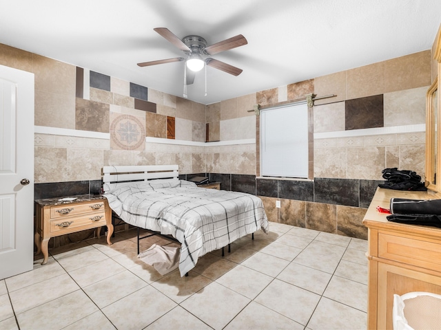 bedroom featuring light tile patterned flooring, ceiling fan, and tile walls