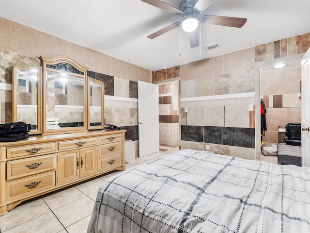 tiled bedroom with tile walls and ceiling fan