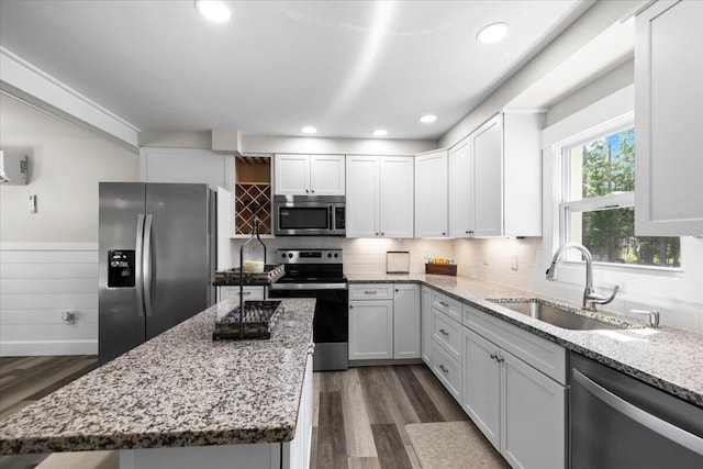 kitchen featuring light stone counters, sink, white cabinetry, and stainless steel appliances