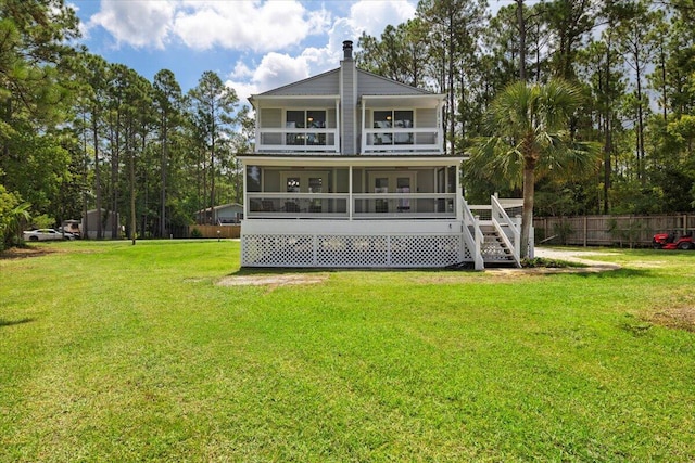 back of property with a sunroom and a lawn