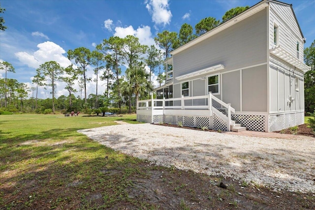 rear view of property with a sunroom and a lawn