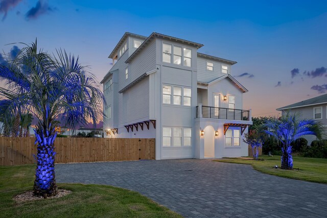 view of front facade with a balcony and a lawn