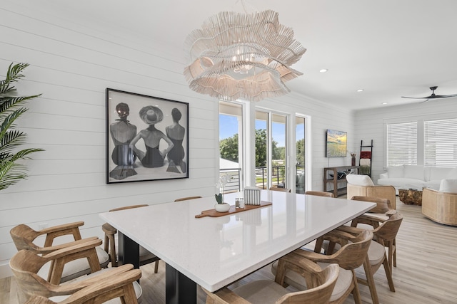 dining area featuring wood walls, light hardwood / wood-style flooring, and ceiling fan