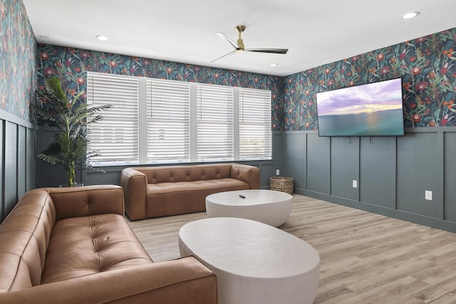 living room with ceiling fan and light hardwood / wood-style flooring