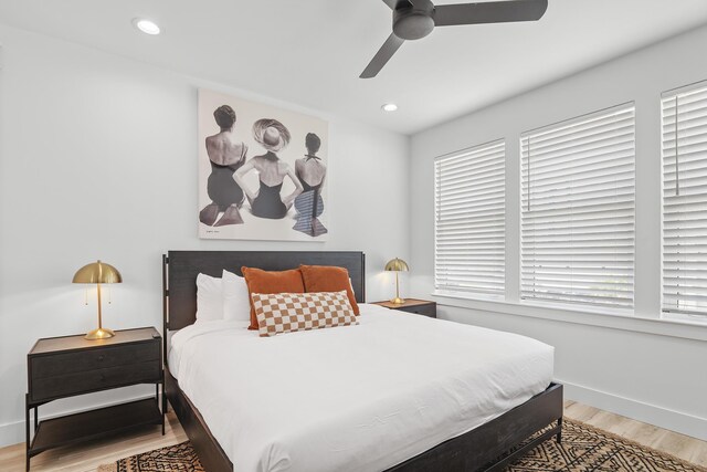 bedroom with multiple windows, ceiling fan, and light wood-type flooring