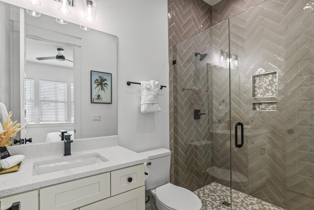 bathroom featuring walk in shower, toilet, vanity, and ceiling fan