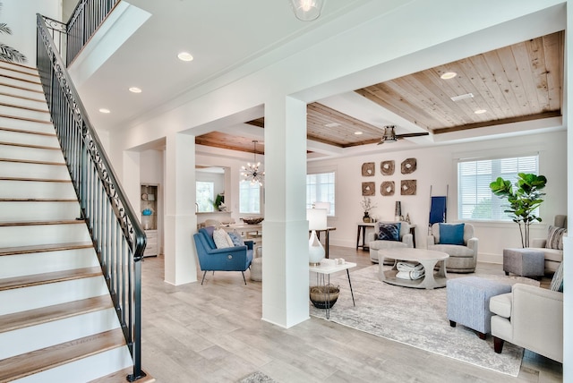 living room with light hardwood / wood-style flooring, wooden ceiling, and ceiling fan with notable chandelier