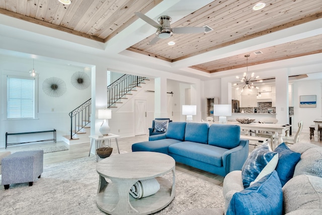 living room featuring ceiling fan with notable chandelier, light hardwood / wood-style flooring, a raised ceiling, and wood ceiling