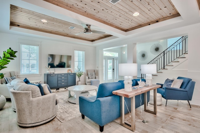 living room with ceiling fan, wooden ceiling, light hardwood / wood-style flooring, and a tray ceiling