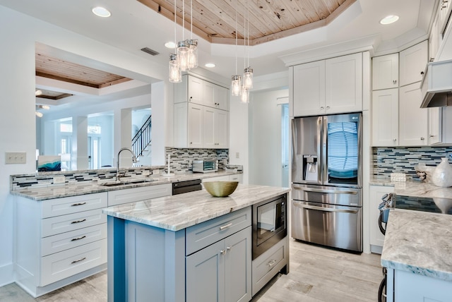 kitchen featuring a raised ceiling, sink, white cabinets, and appliances with stainless steel finishes