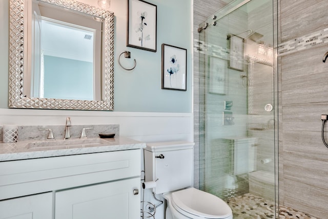 bathroom featuring vanity, toilet, and an enclosed shower