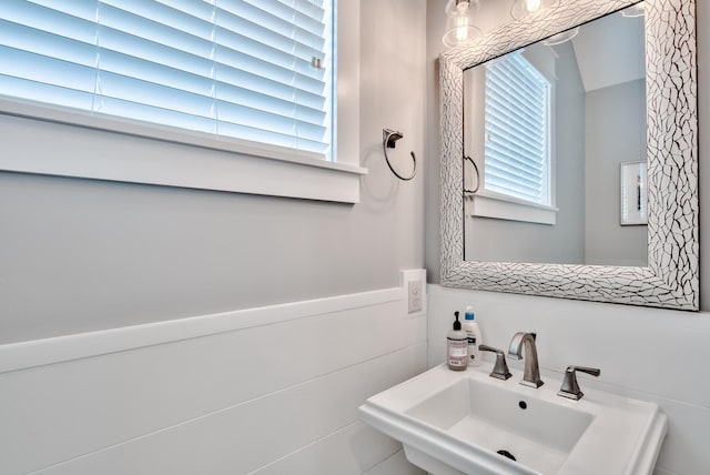 bathroom featuring sink, a healthy amount of sunlight, and tile walls