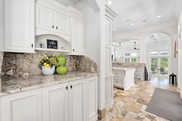 kitchen featuring white cabinets, ornamental molding, and backsplash