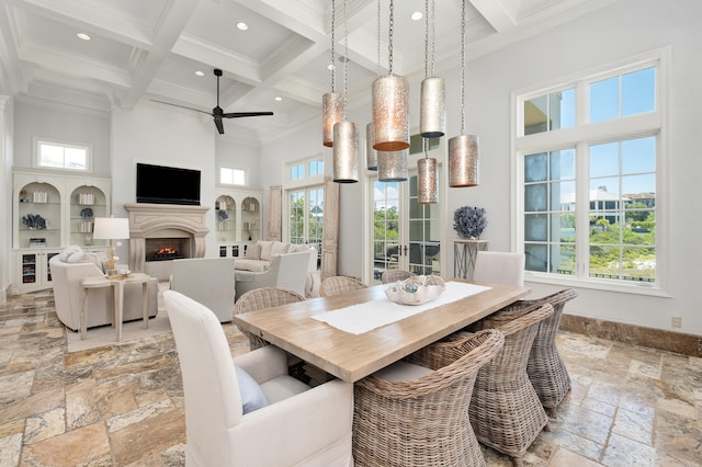 dining area featuring a high ceiling, crown molding, a healthy amount of sunlight, and beam ceiling