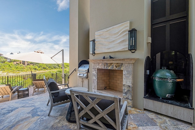 view of patio / terrace with area for grilling, exterior fireplace, and a grill